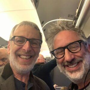 David Baddiel Instagram - Bumped into fabulous comedian and absurdly old mate @ianstonecomedy on the way back from Vienna. Finally we’ve been seen in the same room. Even it is a plane.