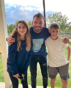 Dean Miroshnikov Instagram - רובכם הכרתם את מלכי גינזברג, לאחר שבעלה סגן אלוף אלי גינזברג נפל בימים הראשונים למלחמה. 
כל מי שצפה בך מלכי, ראה אשה חזקה, שחוותה אובדן של אהוב בפעם השניה בחייה וממשיכה לגדל ארבעה ילדים מקסימים, שנותנת השראה לכולם בעוצמות המבט שלך.
אלי היה המפקד שלי. השתתפתי עם אלי בכמה וכמה מבצעים. כן.. גם במרמרה אלי היה. אני זוכר שהוא פגש אותי על גג סיפון המרמרה כשהייתי כבר פצוע, ועצם הידיעה שאלי נמצא לידי-הרגיעה אותי. כי מי יכול לפגוע באלי. איש ענק וחזק בעוצמות בלתי מוסברות.
את מלכי הכרתי היום לראשונה כשבאתי לבקר לנחם בקיבוץ דוברת, מקום שליו בעמק יזראעל - גן עדן קטן שבנו להם משפחת גינזברג. הכאב והשכול שלך מלכי, ושל ילדייך בלתי נסבלים. אך לפגוש אתכם במציאות, הראה לי עד כמה הביחד שלכם חזק. באתי לחזק ויצאתי מחוזק, יצאתי עם אנרגיות חדשות ועם תקווה בלב. מלכי סיפרה לי שהיא רוצה שיכירו את אלי בכל מקום, שיכירו איזה בן אדם היה, איזה גיבור היה, איזה אבא ובעל טוב היה - מלח הארץ. 
אזכור אותך תמיד אלי, 
כבר התחברתי עם הילדים המדהימים שלך, פגשתי את מיקה, אני זוכר איך סיפרת לנו שהיא נולדה. יפייפיה.
ואפילו סיכמנו שאנחנו חברים.