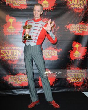 Doug Jones Instagram - Thank you @saturnawards for blessing me with another statuette for Best Supporting Actor in a TV Series, AND for blessing our show @startrek Discovery with Best Science Fiction Series (see photo with our divine showrunner Michelle Paradise)
.
My outfit: A 1980’s marching band uniform jacket, early 1900’s steampunk trousers, and 1970’s disco shoes, thanks to thrift stores and @clockwork_ctr ).
.
#saturnawards #saturnawards2021 #awardshow #award #startrek #startrekdiscovery #saru #kelpien #alien #actor #actorslife