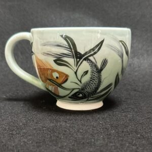 Emily Gravett Instagram - I really wasn’t sure how this would work. If the fish would be visible, whether the greens would shade down in the way I wanted, so I’m pretty delighted with how it turned out.  #ceramicsart #potterylove #porcelain #outofthekiln #teacupandsaucer