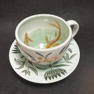 Emily Gravett Instagram - I really wasn’t sure how this would work. If the fish would be visible, whether the greens would shade down in the way I wanted, so I’m pretty delighted with how it turned out.  #ceramicsart #potterylove #porcelain #outofthekiln #teacupandsaucer