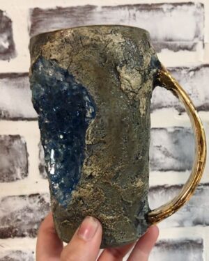 Emily Serpico Instagram - First test of a new style of Geode mug for the holidays, 22k gold handle and rim 💎 This version along with 3 others will be available along with bark mugs, mushroom bark mugs, and mossy bark mugs for the holidays. I will post about it on Thanksgiving ❤️ Thank you guys for all your amazing support and love. #potteryvideos #ceramics #pottery #geode #crystals #gold #clay #geodemug #fauxstone #stonemug
