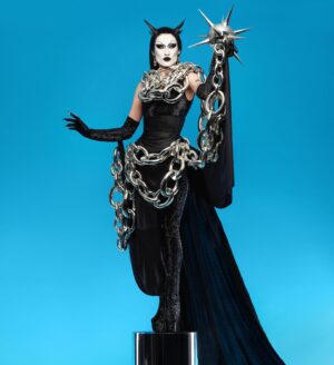 Gottmik Instagram - Wearing custom @loewe on @rupaulsdragrace this week was a DREAM ☠️ thank you to the whole team for making this happen it’s truly such an iconic special moment for me I LOVE YOU 🖤 ⛓️⛓️‍💥loewe doll forever ⛓️‍💥⛓️
.
The bottle's inspiration is drawn from the medieval mace—the 3D-printed and chromed spiked head caps a bottle with a chain that wraps around the wearer. The bottle is paired with a silk jersey corset, draped cape and skirt, and crystal embroidered bodysuit and gloves. 
 

Photo by @sanchezzalba 
Hair by @jeanbaptiste.santens