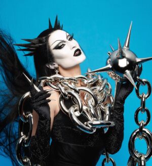 Gottmik Instagram - Wearing custom @loewe on @rupaulsdragrace this week was a DREAM ☠️ thank you to the whole team for making this happen it’s truly such an iconic special moment for me I LOVE YOU 🖤 ⛓️⛓️‍💥loewe doll forever ⛓️‍💥⛓️
.
The bottle's inspiration is drawn from the medieval mace—the 3D-printed and chromed spiked head caps a bottle with a chain that wraps around the wearer. The bottle is paired with a silk jersey corset, draped cape and skirt, and crystal embroidered bodysuit and gloves. 
 

Photo by @sanchezzalba 
Hair by @jeanbaptiste.santens