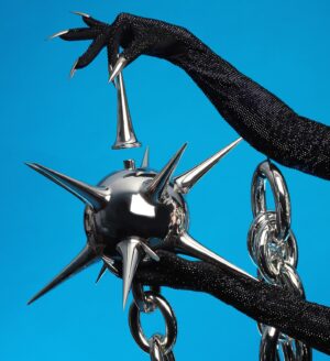 Gottmik Instagram - Wearing custom @loewe on @rupaulsdragrace this week was a DREAM ☠️ thank you to the whole team for making this happen it’s truly such an iconic special moment for me I LOVE YOU 🖤 ⛓️⛓️‍💥loewe doll forever ⛓️‍💥⛓️
.
The bottle's inspiration is drawn from the medieval mace—the 3D-printed and chromed spiked head caps a bottle with a chain that wraps around the wearer. The bottle is paired with a silk jersey corset, draped cape and skirt, and crystal embroidered bodysuit and gloves. 
 

Photo by @sanchezzalba 
Hair by @jeanbaptiste.santens