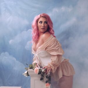 Hayley Sproull Instagram - I was going to wait but I simply cannot resist. Shoutout to @michellehyslop on the camera for bringing my vision to life. Shoutout to @sharihairmakeup for my pink hair dreams and romantic make up and for on set ‘fluffing’. And shoutout to carbohydrates for my honking rack. 

Wild Flutters as part of the Best Foods Mayo NZ International Comedy Festival will be on sale soon! 
#comedy #nzicf