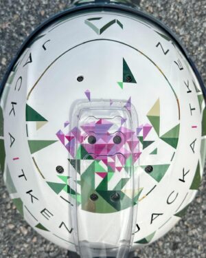 Jack Aitken Instagram - I proudly present to you the latest Aitken x Koop collab, courtesy of @stilo_official. The Thistle. 🌷

Inspiration came from the classic emblem of Scotland, the thistle, a prickly yet beautiful flower that blooms bright purple from the cold greens and greys of the British countryside. The little dashes of gold were thrown in to set off the muted greens and bright purples. On the back we have the motto of The Order of the Thistle (yes it’s a thing), which translates to “Nobody attacks me with impunity”, referring to our prickly nature. Let’s hope that rings true this season 😉 I’m glad to see it’s already been given the thumbs up by a few of you (swipe to the end)! 

#BeIconic #CadillacRacing 

Final pic 📸 @bcpix