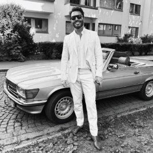 Jan Thomas Instagram - Da jeg var liten hadde jeg en matchbox bil. Mercedes Benz 450 SL. Det var faktisk drømmebilen. Fikk muligheten til å kjøre en noen ganger de årene jeg bodde i USA. Men, som sangen sier det ble Porsche til slutt. Gleder meg som et barn til å få min nye «vidundergutt» neste uke. Har ikke peiling på hvem som eier denne bilen, men på vei hjem fra 17. mai feiring syntes Harlem at den passet veldig godt til dressen min så han tok dette bildet.☀️🥳
