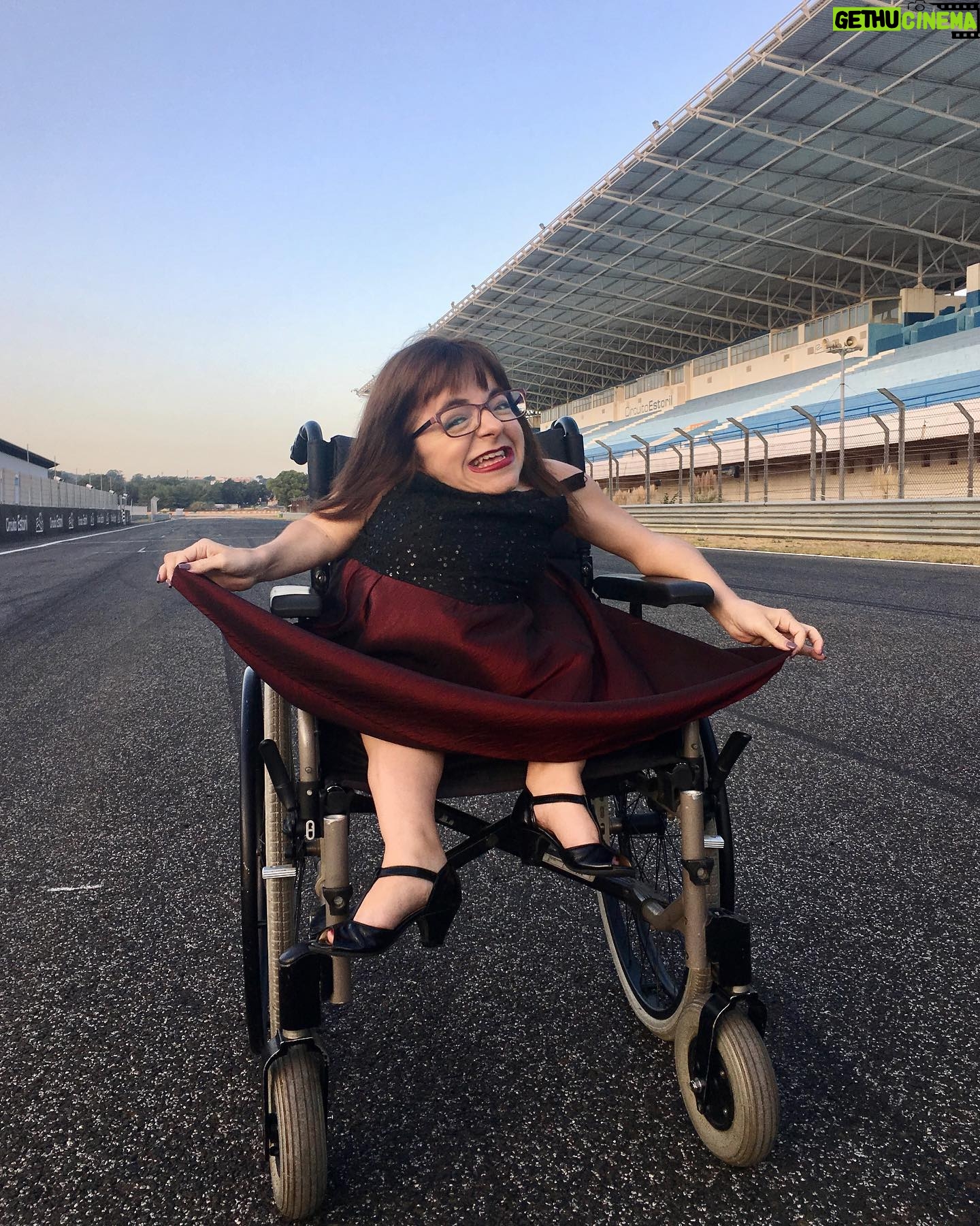 Mafalda Ribeiro - 303 Likes - Este era o meu entusiasmo em 2017 face ao desconhecido, onde as minhas rodas iriam pisar, até chegarmos ao dia de hoje. Estava numa pausa das gravações do único video que fiz para o meu projecto Sorrir sobre Rodas - de e com propósito - cheia de frio, mordida pelas melgas, mas determinada em investir na propagação da mensagem que trago, nesta embalagem acondicionada, como a única estrada onde sei andar. Quem me empurrou para este dia, e se doou em competências e talentos, trouxe não só um valor acrescentado a este vídeo, como sublinhou o meu próprio valor como ser humano mesmo que eu nunca viesse a realizar nada. A vida aconteceu e através dela houve a oportunidade do vídeo ser visto milhares de vezes. Sempre que eu própria o vejo - embalada pela voz off do meu querido @albanojeronimooficial - sinto que vou mais um bocadinho para a frente rumo a novos territórios e honro a fonte da minha existência peculiar.
Em véspera de mais uma ida, vestida de responsabilidade e nervos, sinto-me, ao mesmo tempo paradoxalmente, vazia de mim própria e confiante de que a minha história é por si só uma plataforma de poder. Depois vou tendo rasgos intermitentes de criança inconsciente, ou de ET recém aterrada, que pergunta: “como é que eu vim aqui parar?” Não olho para o chão que não piso como conquista, meritocracia ou sonho realizado. Mas acredito que é o resultado de neste tempo todo nunca ter feito inversão de marcha. Querer continuar a ir, independentemente da velocidade e das circunstâncias tantas vezes desfavoráveis, é de alguém que mesmo sem entender nunca perdeu a direção. Aprendi a transformar as perdas em lições e assim vou permanecendo firme nas convicções. A maior de todas: dar-Lhe graças com a minha vida! O resto é andar, nem que seja só com a cabeça ou com as palavras que saem da minha boca e da ponta dos meus dedos. É a andar que sou feliz! #gotasnocharco #sorrirsobrerodas #eusou #esperanca #gratidao #novodesafio #entusiasmo #autodromodoestoril #video