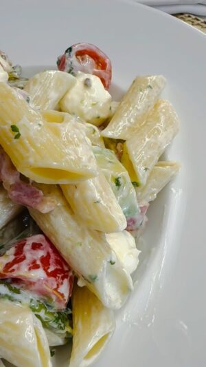 Manuel Luís Goucha Instagram - Fiz uma salada fria para o almoço com massa, espargos previamente salteados em azeite, cubinhos de bacon salteados na própria gordura, tomates-cereja, cubos de abacate, bolinhas de mozarella e “cornichons” (pepinos de conserva). Para o molho utilizei  iogurte natural, fio de azeite, três dentes de alho esmagados e coentros picados. Tempero de sal e pimenta preta. Tudo bem misturado.