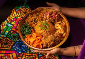 Marcus Samuelsson Instagram - Family style meals are universal, but they really do it well in Ethiopia. Just look at this gorgeous Grand Feast Jollof platter at @MarcusAddisAbaba, piled with curried goat, braised lamb, chili shrimp, sweet gomen, roasted vegetables, and jollof rice. Perfection!
