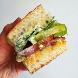 Megan Mitchell Instagram - Honey Sriracha BLT with a lemony herb mayo. Recipe👇🏼⁣⁣⁣
⁣⁣⁣
Ingredients:⁣⁣⁣
• 8-9 pieces thick cut bacon⁣⁣⁣
• 1/4 cup sriracha ⁣⁣⁣
• 1 tbsp. honey⁣⁣⁣
• 3/4 cup mayo⁣⁣⁣
• 1 lemon, zested⁣⁣
• 2 tbsp. minced chives⁣⁣⁣
• 1 tbsp. dijon⁣⁣⁣
• 3 large heirloom tomatoes ⁣⁣⁣
• ciabatta, sliced into 4 squares and toasted⁣⁣⁣
• flaked sea salt, for sprinkling ⁣⁣⁣
• freshly cracked black pepper, for sprinkling⁣⁣⁣
• 12-16 romaine leaves ⁣⁣⁣
⁣⁣⁣
Directions:⁣⁣⁣
• preheat oven to 400F⁣⁣⁣
• line a sheet tray with foil then place a cooling rack on top ⁣⁣⁣
• lay the bacon on the tray so they aren’t touching ⁣⁣⁣
• bake for 25 minutes ⁣⁣⁣
• in a small bowl mix together the sriracha and honey. Brush onto the bacon then place back in the oven for another 10 minutes or until bubbly and crispy ⁣⁣⁣
• in a small bowl mix together the mayo, lemon zest, chives and dijon ⁣⁣⁣
• slice the tomatoes 1/2-inch thick⁣⁣⁣
• to assemble slather both insides of the bread with some of the mayo⁣⁣⁣
• next add the bacon, cut to fit, followed by the tomatoes sprinkled with salt and pepper⁣⁣
• finish with ⁣lettuce and place on the top⁣