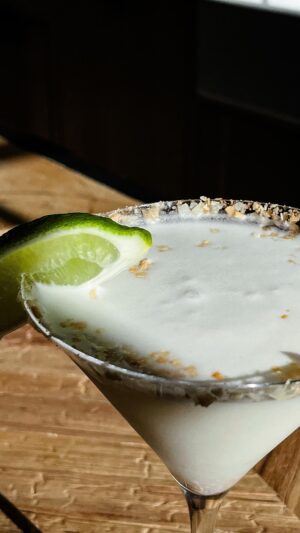 Michael Symon Instagram - DELICIOUS AND DANGEROUS!!!! This white margarita is a perfect transitionl cocktail. Warms you up in the winter, refreshes you in the summer! 🌞❄️ .. let me know who tries it out this weekend…. Full recipe below!! 

White Margarita 🥥🍋
Makes 2 cocktails 

Ingredients

4 Limes (1 quartered, 3 juiced)
Toasted Coconut
3 oz. of blanco tequila of your choice
2 oz cream of coconut
1 oz of orange liqueur 
One handful of ice

1 Cocktail Shaker 
2 Martini glasses

Put toasted coconut into a shallow dish. Take a lime wedge and pass along the rim of each martini glass, then press the rim of the glass into the dish with the toasted coconut to garnish. Add lime wedge to the edge of the glass for an additional garnish.

Combine lime juice, cream of coconut, orange liqueur, tequila and ice into the cocktail shaker. Shake hard, for about one minute. Pour cocktail into the garnished martini glasses and enjoy!