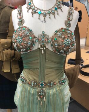Michele Clapton Instagram - The Kings Men costumes. Here are some illustrations and fittings for Mata Hari.. A little artistic license taken with her costumes here but we based the looks on shapes that in research we noted that she wore. I loved this dark green fabrics sheen, it had depth and weight and a drape that is often missing in cotton satin. It was similar to the wonderful Glendina from Whaleys ltd.. my go to fabric of choice!!..We knew it would light well in low light which we anticipated would often be the case for her scenes in the script. I felt that it still needed a detail of extra texture so we stitched parallel lines following the shape of the collar and pocket flaps. We also had made some beautiful two tone button boots which I can’t find a photo of but these are the shoes we designed for another of her looks.. Valerie Pachner the actress was so lovely to collaborate with and endlessly patient. We had to create this jewelled and metal Mata Hari performance piece that she had to dance in for the American President. Although we don’t see much of this costume or performance in the way the scene was shot ( we were a little heart broken) Valerie was incredible as were all of the costume team involved.
