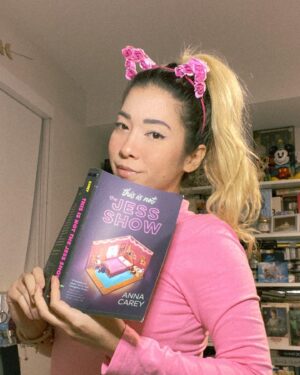 Michelle Grondine Instagram - Q: if you could live in any fictional world, which world would you live in, even if you knew you might not be able to return to your own reality? 

HAPPY BOOK BIRTHDAY TO ✨𝑡ℎ𝑖𝑠 𝑖𝑠 𝑛𝑜𝑡 𝑡ℎ𝑒 𝕁𝔼𝕊𝕊 𝕊ℍ𝕆𝕎✨ by @annacareybooks !!!!!!! which is out from @quirkbooks ᴛᴏᴅᴀʏ 🥳🎉

i am currently in the thick of this book—a Black Mirror meets My So-Called Life with maj YA The Truman Show vibes—and loving every second. i will not disclose whether i am reading slowly because i am trying to make this world last for me (does anyone else do this???)

when this Ithaca College alumni saw the main character, Jess, was simping over a thrifted tee that upstate new yorkers will know dearly and love, i knew i was in for a treat.

jess’s voice is charismatic, inviting, and engaging, and i feel like i’m hanging out with one of my best friends when i’m reading along, which is one of my favorite feelings to experience when i’m reading.

i’ve recently come to the realization that stories that examine the gap between fiction and reality are the stories i gravitate toward the most. 

two of my most recent fav kdramas—W and extra-ordinary you—are both about the line between reality and the manhwa world.

if you are like me, and you love stories that ruminate the line between fiction and reality, This Is Not the Jess Show is for you. 

further, i have an 110-film (at present) letterboxd list titled, “what is reality?” comprised of films that i have watched which are meditations, ruminations, and explorations on the nature of reality and existence. find me @tediously_brief or click the linktree in my bio for a link to the curated film list :))

could be more excited for everyone to also finally get to read This Is Not The Jess Show !!! peep the comments for the full synopsis of the book!