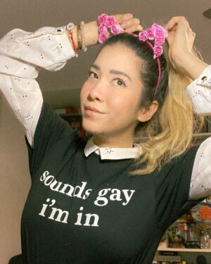 Michelle Grondine Instagram - a few september favorites:
- Ask A Queer Chick: A Guide to Sex, Love, and Life for Girls Who Dig Girls by Lindsay King-Miller @askaqueerchick,
- this ‘sounds gay i’m in’ shirt from @thtsoundsgay (use code travelingbooknerds to get 30% off your entire order). proceeds from @thtsoundsgay website sales are donated to youth GAS orgs and leaders across 🇺🇸 via @gsanetwork;
- freaking romance by @snailords on @webtoonofficial is a god-tier toon and zylith has given me the confidence to simply exist with cat ears at any time i desire (these are from @flowerchildrenonly). also every character is amazing and i ship both zylith   verose *and* zylith   the lavender scented ultra soft soft boy aka zelan;
- ‘bi-fi signal strong’ pin ‘cause puns 😆 (ps: happy bi  visibility month!);
- this collared crop top covered in kitten faces. (need i say more?);
- this eyeliner kitten wing that i somehow got evenly on the first try for both eyes that was some sort of magical manifestation come to life that i’m glad got documented for personal history purposes.
—————
q: what are some of your current obsessions?