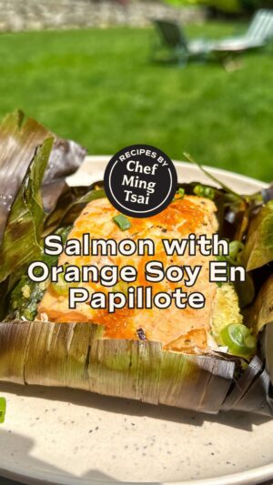 Ming Tsai Instagram - Get ready to fire up the grill and treat yourself to Chef @Mingtsai’s mouthwatering Salmon with Orange Soy En Papillote recipe! 🔥🍊

INGREDIENTS
1 package Banana Leaves
12-16 oz Salmon, cut into 2 even pieces
1 cup cooked Couscous
1 cup Raw Spinach 
1 bunch Thai Basil 
2 Tbsp Sweet Soy Sauce
1 Orange, zest and juice into one bowl
EVOO
2 Tbsp scallion greens, sliced
Kosher salt and freshly ground pepper

INSTRUCTIONS
1) Cut banana leaves so you have 2 pieces about 18 inches in length and 12 inches in width, place on a dry surface with the long side facing you. 
2) Season salmon with S&P on both sides. 
3) Make Orange Glaze: mix zest, juice and sweet soy in a bowl
3) In the center of your banana leaves add ½ cup of couscous in a mound, hand rip ½ cup spinach on top of the couscous, and then add about 3 thai basil leaves. Top with your salmon, placing it so the long side is facing you. Spoon ½ the of Orange Glaze over salmon. 
4) Fold in the right and left edge of the banana leaf over the salmon, then fold the top and bottom underneath. Creating a pouch (repeat for second piece of salmon). 
5) Place on grill, close lid and grill for 15-17 minutes (thermometer should read 135-140 when finished). 
6) Remove from grill and place on a plate. 
7) To serve: carefully cut open your pouches with kitchen scissors. Top with the rest of the Orange Glaze, a drizzle of EVOO and scallion greens. ENJOY! 

🌟 Make sure to SAVE this recipe to make later! 🌟

#grillmaster #grillrecipes #salmondinner #salmonrecipe