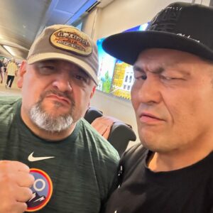 Minoru Suzuki Instagram - TAZ

早朝から空港へ。空港内でTAZが話しかけてきた。「昔さパンクラスのビデオを見た時にビックリしたんだよ。オレと同じ黒いタオルをかぶって入場しててさ。みんなに同じギミックだ！って言われたけど、オレ会ったことも無いんだぜ？って言ってたんだよ。一度ちゃんと話したかった」オレもそんなことになってるなんて全く知らなかった。当時の写真を見せてくれたが、確かに同じだった。オレはオレでオリジナルだと思ったが同じ時期から同じことしてたなんてな。これもまた縁。世界は広いけど、狭くもある。自分の見ている世界が全てだと思いがちだが、見ていない、見たことない世界の方が広いんだ。どんどん自分の世界を広げていこう。。。