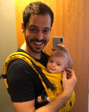 Murilo Meola Instagram - Não resisti à selfie de espelho!! Foi inevitável!! Olha só o sorriso de quem vai passear e tomar cerveja!! 🤣🤣 o outro é o sorriso mais lindo do mundo pronto pro rolê numa mochila de mico-leão 🐒 ☀️ 
Eu coloco a mochila e ele já sabe que vai passar 🤣🤣🤣 acho… 

PS meu insta está monotemático confesso! A culpa é dele! Me ganha fácil!! 
#paiefilho #slingévida #slingueiro