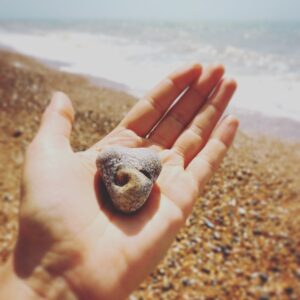 Natalie Gumede Instagram - It caught my eye amongst millions
This stone with a swirl at its heart
Its form of love, with a crashing wave
Mirrors the ways I want life to restart

Perhaps its imprint is from a shell?
Edges surely, smoothed by the sea?
A lesson - as I emerge from a personal hell
Of how we are meant to be

Yielding, morphing, staying strong 
Nature won’t assign these emotion
From the years a pebble is broken down
It eventually becomes the ocean

I felt the breaking, yet drowned by the waves
In a vast beach I tried to hide
But this rock sat proud, with its perfect flaws
Asking ‘when will YOU turn the tide?’ My shape isn’t perfect, my edges still rough
Sea spray tastes the same as my tears
But sharpness can soften; I know I’m enough
And our love can stand out from fear

It’s good for ego to remember 
We’re naught but a grain of sand
But sometimes we need the reminder
The soul has bigger things planned

Pebble Heart holds the answer
To sensing the storms of the sea
‘When you feel small compared to the ocean
See the ocean is also in me.’ 24/05/20 - Thanks Pebble Heart!

Sometimes I write poems to make sense of how I feel. I rarely share them. And if I do, only with a few people. I saw this pebble today. And I decided to be brave 💙💛💙💛💙💛💙💛💙💛💙💛💙
#poetry #poems #healing #selfhelp #wellness #mentalhealth