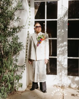 Nico Santos Instagram - Ok reposting coz some pics weren’t showing up…Wanted to share some more images that our incredible photographer @logancolephoto captured on the big day...  

My husband @zekerchief is the cutest 😍😍😍
  
A lot of y'all have been asking about my wedding look so here's the breakdown:   
  
Boutonnière: @cobralily of course! I wanted a statement and I got it!   
  
Frames: custom made by @romainkayo_eyewear! They have these lovely brass magnetic purple ombré sunglass lenses that I made good use of when the sun was blaring..  
  
Jacket: @driesvannoten that I got online for like 80% off. I've had my eye on this jacket forever (she loves a good deal henny!) but chose it because the shoulders was giving slight Filipiniana Terno vibes.   
  
Barong/Pants: custom made by the amazing @veejayfloresca! I knew I wanted an extra long barong because I wanted it to evoke bridal. And wide leg pants coz that's all I'm wearing nowadays lol   
  
Shoes: @paulsmithdesign, the first pair of tux shoes I ever bought years ago!   
  
  
But also LOOK AT THESE FIERCE QUEENS!!! @justjolopez @nebuyaystyles and @aianashaw gave us EVERYTHING and made the night even more memorable. 

🩷❤️🧡💛💚🩵💙💜🤎🖤