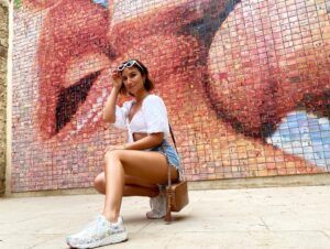 Nicole Dambro Instagram - This kissing wall in Barcelona is made up of thousands of small photos of people in love 😍 My friend @alistackhouse and I knew we had to go kiss our lovers in front of it too! 

And get this: I decided to bring the “Love Wall” from LA to this “The World Begins With Every Kiss” mural… on my feet! 

Call me nerd, but I thought it’d be cute 🥰 Also, not to keep geeking out over these special edition @jgoldcrown x @skechers, but they were SERIOUSLY comfortable as we traversed the city on our adventure! Not only were my feet safe due to the extra cushion-y sole, but they were also cute AF and matched all of my colorful summer outfits 😎🙌 

Always a big fan of street artists, and an even bigger fan of love. ❤️🧡💛💚💙💜 Thank you @skechers for sending me the cutest sneakers in my wardrobe! 

#sponsored #skechersxjgoldcrown #lovewall #jgoldcrown #jgoldcrownart #skecherstyle #skecherswomen #lovearoundtheworld #loveart #loveartwork #heartart #heartartwork #mosaicart #mosaictile #theworldbeginswitheverykiss #barcelonasightseeing #barcelonasecrets