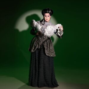 Nina West Instagram - Never a bridesmaid. Always a bride. 👰🏻🩶🪓💍

Proud nerd here. Major geek. And I am really amped that I got to do this runway the way I did it, all Haunted Mansion inspired!  There is something about the great storytelling behind Disney’s Haunted Mansion. It’s that @waltdisneyimagineering 🪦 From the start of the queue all the way through to the very last step outside of the attraction, the story of Gracey Manor and its inhabitants has been one that has fascinated me for years. And in this runway, I got to bring to life my own ghost bride. 

First, I should say, when we were given the prompt of “Widow, Weep For Me” - the name of the 1st episode in the second season of Murder, She Wrote, my mind when to a Jessica Fletcher inspired runway look, but my heart went to this Haunted Mansion story. In her earthly existence, Beth Knell was addicted to getting married. But what to do with all those husbands she was collecting? Don’t axe me! 🪓That secret is buried deep! But I think I hear wedding bells…again! 🔔💍

👗 @florencedlee 
🎩 @thedragdandy 
💄 @callitodeh 
📸  @jenniferlenglert 

Dress design sketch by @florencedlee 

#rupaulsdragrace #allstars9 #ninawest #nineconic #hauntedmansion
#florencedlee