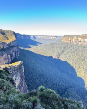 Rae Johnston Instagram - The sun and moon sharing the sky, sandstone paths, grass trees, huge ancient cliff faces, and that beautiful river flowing in the deep valley below 🤎 

Today’s walk on Wiradjuri, Darug & Gundungurra Country - making the most of the clear skies while they last, looking wet and below freezing next week! 

#bluemountains #rigbyhill #piercespass #wiradjuricountry #darugcountry #gundungurracountry