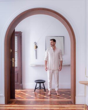 Renato Mendonça Instagram - Na porta de entrada do @espacoarquetipo, um corredor organiza o fluxo dos pacientes entre recepção e sala de psiquiatria. Mais do que um ambiente de passagem, a composição destaca a arquitetura, como este belíssimo arco estrutural. 

Ao fundo, criamos um aparador de pedra sabão engastado na parede, que remete a uma ruína. A composição com a porta original, arandela do @estudioorth, gravura de Barsotti, banco de Sérgio Rodrigues e vasos de @jacquelineterpinsestudio mescla delicadeza e potência. 

📸 @rafaelrenzo_fotografia
✨ @filipecamargoestudio

#renatomendonca #decoração #decor #arquitetura #projeto #projetocomercial #clinica