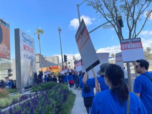 Siân Heder Instagram - We’re on strike. Writers are the driving force behind film and television. We are responsible for creating, writing and producing more than 4,000 episodes of scripted programming and hundreds of films each year. We are asking for less than 2% of the Hollywood profits these massive corporations make off our work. And yes that means I’m picketing in a boot with a broken foot. #wgastrong