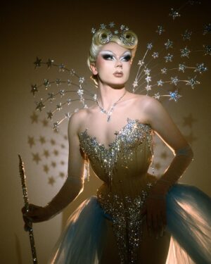 Starlet Instagram - Ru Are You💙💫

For Ru Are You I definitely wanted to go heavy on the old Hollywood glam, as it’s an era my drag is very deeply rooted in but I also wanted to reference things symbolic to me like stars and the colour blue. I drew inspiration from old glamour showgirls and actresses like Lana Turner in Ziegfeld Follies and my favourite film Cinderella. I couldn’t be happier with how this look came out💙✨💫

Hair: @carlbrownhair stoned by me✨
Corset: @misty_couture stoned and embellished by me✨
Wings and Wand by me✨
Photo: @jamie_noise 

With special thanks to @siblingstudios_ and to @fensuss for helping out on set💕