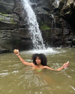 Ajani Russell Instagram - Bliss is truly just eating a coconut you opened with only your hands under a waterfall.

I went on a very special retreat with @theintuitionschool.co last month. I attended as a cohost and a teacher but I learned so much on this trip I might as well have been a student. So many lessons and experience that will never  be articulated because the land doesn’t speak english. This particular day at the waterfall I released something that no longer served me, I saw many lil frogs and I learned how to crack open a coconut on a rock (El saw me do this and said ‘damn you’re carribean af’ 😂) I reconnected with myself and my roots in ways I didn’t know I wanted but definitely needed. The first of many Costa Rica photo dumps. Can’t wait to share the rest with y’all. 🫶🏾