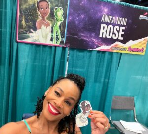 Anika Noni Rose Instagram - A wonderful day at @galaxyconraleigh! Thank you kind, beautiful people for all of the gifts you gave and the gifts you shared-sometimes all in one. 

Thank you to all of you who wore masks.

Thank you to every one of you who stopped by and shared your loving hearts with me. 

See you tomorrow!

Remember, if you have a mask, if you just want any to be cautious, if you THINK you don’t feel well, please mask up. If you KNOW you’re sick, consider staying home. These lungs can’t take a bout with the 🦠

Let’s keep each other safe out here! 
See you tomorrow for the panel!
💚👸🏽

1. @Raycayz, I got my sticker and I love it! Thank you!!
💚
2. Coloring from sweet baby Mila, and first friendship bracelet of the weekend 
💚
3. Gorgeous embroidery frog necklace from @natsnostalgicstitches
💚
4. Amazing Tiana art by @flocolores
💚
5. Some more gorgeous art, by sweet @artbyannae . Thank you for your beautiful talent and huge heart🥰

Thank all of you for a beautiful day!

Hair I love by @indiamhammond 
Onesie by @martinesdream 

#galaxyconraleigh #galxycon #princessTiana