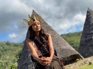 Aurélie Moeremans Instagram - Di belakangku adalah rumah tradisional yang menyimpan sejarah kelam namun penuh makna di Kampung Todo, Manggarai. Rumah ini menyimpan gendang yang terbuat dari bagian perut seorang perempuan cantik yang menjadi rebutan tujuh kerajaan dalam legenda lokal.

Konflik di antara kerajaan-kerajaan ini begitu kuat sehingga diputuskan untuk membelah tubuh perempuan itu menjadi tujuh bagian, agar setiap kerajaan mendapatkan satu bagian tubuhnya. Tempat penyimpanan tamburin ini hanya dibuka saat upacara adat dengan ritual, karena dipercaya jika dibuka di luar itu akan membawa kesialan.

Sebuah pengingat akan tradisi dan cara nenek moyang kita dalam menyelesaikan konflik, meskipun terdengar tragis, cerita ini menjadi bagian tak terpisahkan dari warisan budaya kita. #Manggarai #TodoVillage
