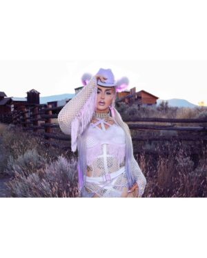 Ilona Verley Instagram - “You were a mirage, you’re not really there”
🐎🐎🐎🐎
Inspired by @slayyyter & the cowboys music video!
🐎🐎🐎🐎
This look was originally made for me a few years ago by @connormccalden who did up the chaps/ bra & gloves for me when I was in Toronto for a few months and running out of outfits at the time!
I later made the hat and the bodysuit to go with it & @hauszuk helped me stone everything! 
🐎🐎🐎🐎
I’m so happy to have finally gotten to shoot this look & to do it with my incredible mom @sandiverley who took off a whole weekend to drive us up home to the canyon and literally camp until it was cool enough for us to drive to the ghost town to actually shoot… our one day trip turned into a 3 day adventure!
THANK YOU MOM!
🐎🐎🐎🐎
Hair was done for me the MORNING of by @the.girlfriendexperience
Also a big shout out to sheisbliss for helping me stone and get myself together that morning as well!
Hat was originally from @rockin_cowboy_clothing_company painted and transformed by me! (Reel coming soon on the DIY) 
Boots were from @onlymaker_shoes transformed by sheisbliss & myself! 
Earrings by @sadndn_ 
🐎🐎🐎🐎
I used to try to be so independent and do everything myself, but the last little bit, I’ve been giving up the perfection complex of wanting to do it all alone & it has helped me see that creating is not only easier but much more rewarding when you work with others, especially the people you LOVE!
The funny thing is to me the most perfect art has been the stuff I’ve done with friends… not the stuff I’ve done alone… (learning lesson for those struggling with giving up control / dealing with the typical artist perfection complex) 
🐎🐎🐎🐎
#cowgirl #cowgirlfashion #cowboyhat #purple #lavenderhair #humanhairwig #drag #dragqueen #purplemakeup #onlymaker #festivalfashion #ravegirl #ravegirls