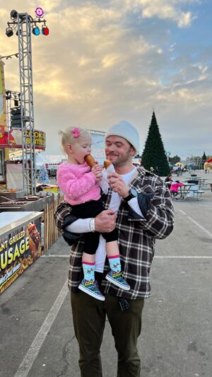 Kellan Lutz Instagram - Had the best time at #winterfestoc this year with the family! Corn dogs, ice skating, sledding, bounce houses, dancing and so much more! We didn’t know the holidays could get any sweeter until this year seeing them through Ashtyn’s eyes 🫶🏼🥹 
Thanks @thebrandamp for helping us make some special memories!