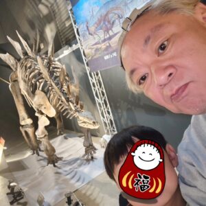 Osamu Suzuki Instagram - 笑福と二人の福井旅。僕が放送作家辞めてから妻が前のようにかなり働き始めました。
昨日、今日も仕事だったので、福井の恐竜旅
いきなり福井駅で、恐竜がお出迎え。
で、恐竜博物館
リニューアルしてから、さらにすごいと
前は妻と、１５年ほど前にいきました！
そんで、恐竜博物館
とんでもないパンチ力！
谷川由美子館長もご挨拶してくれまして。
すごく素敵な館長さんだな。
いま、特別展示で、カナダのティラノサウルスの頭蓋骨でブラックビューティーと呼ばれる本物の頭蓋骨が日本初公開で超人気。
いや、すごい、パワーと迫力
僕もいままで、沢山、恐竜展見てきましたが、これは
すごい力
必見！
恐竜博物館行くまでは、今回、福井駅から恐竜博物館館まで出ているXRのバス「WOW RIDE」に乗りました。
これ、堤幸彦さんが演出的ポジションということでめちゃくちゃ気になってて。
バスに乗ると全部の窓がモニターになっていて
どういうこと？
で、スタートすると、物語のVTRが流れる。
今井翼さん主演で、恐竜の物語なんだけど
途中から、実際に走ってる車窓からの景色と
恐竜が混じっていき、、、
これは初体験の新感覚！
息子、笑福は、「超面白かった！」と。
恐竜博物館に行くまでの１時間、かなりのおもしろい体験が出来ました！
レストランのフードもおいしく！
いやー、福井恐竜旅
最高です！！！

15年前に妻と二人で行った場所に、こうやって息子と二人で来れて良かった！