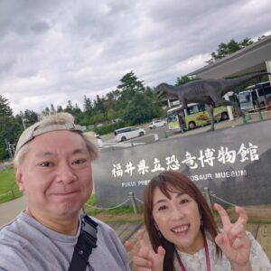 Osamu Suzuki Instagram - 笑福と二人の福井旅。僕が放送作家辞めてから妻が前のようにかなり働き始めました。
昨日、今日も仕事だったので、福井の恐竜旅
いきなり福井駅で、恐竜がお出迎え。
で、恐竜博物館
リニューアルしてから、さらにすごいと
前は妻と、１５年ほど前にいきました！
そんで、恐竜博物館
とんでもないパンチ力！
谷川由美子館長もご挨拶してくれまして。
すごく素敵な館長さんだな。
いま、特別展示で、カナダのティラノサウルスの頭蓋骨でブラックビューティーと呼ばれる本物の頭蓋骨が日本初公開で超人気。
いや、すごい、パワーと迫力
僕もいままで、沢山、恐竜展見てきましたが、これは
すごい力
必見！
恐竜博物館行くまでは、今回、福井駅から恐竜博物館館まで出ているXRのバス「WOW RIDE」に乗りました。
これ、堤幸彦さんが演出的ポジションということでめちゃくちゃ気になってて。
バスに乗ると全部の窓がモニターになっていて
どういうこと？
で、スタートすると、物語のVTRが流れる。
今井翼さん主演で、恐竜の物語なんだけど
途中から、実際に走ってる車窓からの景色と
恐竜が混じっていき、、、
これは初体験の新感覚！
息子、笑福は、「超面白かった！」と。
恐竜博物館に行くまでの１時間、かなりのおもしろい体験が出来ました！
レストランのフードもおいしく！
いやー、福井恐竜旅
最高です！！！

15年前に妻と二人で行った場所に、こうやって息子と二人で来れて良かった！