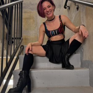 Sandra Mae Frank Instagram - Happy Pride! 🌈🤟

#Pride 

📸 - @christafah 

[Image Description]
Sandra Mae, with dusty pink chin-length hair (thanks to @monetmoonhair), is wearing a black/rainbow cut-out bodysuit with a black skirt and black boots. She’s doing poses on the stairs. The first photo - looks up, laughing, and the second photo - looks at the camera, smiling.