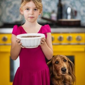 Silvia Colloca Instagram - One of my favourite shots by @alan_benson_photographer for my latest book, ITALIAN FAMILY FOOD. Luna and Mabel captured in magical light, like characters from a quirky Wes Anderson movie. 
Mabel (canine) is showing the signs of that longing that only chocolate pudding (which Luna, human, is stoically carrying in a retro Tupperware mould) can inspire. 
❤️🇮🇹 🐕