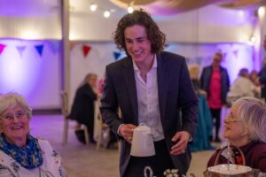 Sarah Beeny Instagram - The @kingsfdn at @dumfrieshouse host monthly tea dances to bring together members of the local community at risk of loneliness or isolation to socialise while enjoying live music and an afternoon tea. 

When I visited @dumfrieshouse I was bowled over by how much care and professionalism the staff put into these dances, and so inspired. 

I am so grateful to the incredible Royal butlers, Evan and Gavin who helped us to host a similar event, the most joyous event I have ever had the privilege to host. 
Thank you so so much Evan, Gavin, @dumfrieshouse @kingsfdn and the wonderful @ageuksom team who trusted us with their 75th Anniversary party and to look after such precious guests. 
I don’t often say this and probably should say it more - thank you @the_entitled_sons ❤️xxxx. If you missed it, catch up on @channel4 #sarahbeenynewlife