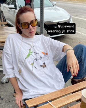 Alie Ward Instagram - Hi, I got Instagram-shy for a while but I’m back with a dump. Pictured: me doing a very good job modeling a #JBStink shirt which I like —thank you @jarrett_sleeper — a sweater I maybe should have spent $150 on but didn’t, a swing at Hutton Brickyards as captured by @katmburns, a BMW Isetta (a top tier automotive), more upstate with Kat Burns for the wedding of @mckenzieblairrollins & @joshdmeyers, during which your podmother and I wept so much, Jarrett receiving nightvision as a bday gift from a bunch of us to fulfill his lifelong dream of lurking in forests, the #PumpkinBlaze in CT with family/hooligans, camping in our driveway, a #nightjar in the yard, finding the exact military surplus shoes I had in highschool on ebay and I want to kiss them, moderated a panel in NYC during UN Climate Week for @wildlifejustice_official and learned about the pangolin trade in Nigeria, Jarrett fell asleep in a cab, learning that the Anxiety character in Inside Out 2 likes stripes and tea and has a fountain of unkept red hair, getting quality time with @commanderscraps while @simonegiertz left town, and finally getting up at 5am to return home wearing a Snuggie under my winter coat because it wouldn’t fit back in my suitcase. Not pictured: the wonderful wedding of @aliceramshaw & @mike.natter, the pair of owls that swoop over our deck at dusk, the massive amount of green tea bags and emergen-c packets I travel with. Okay nice catching up.  I hope you are crunching leaves.