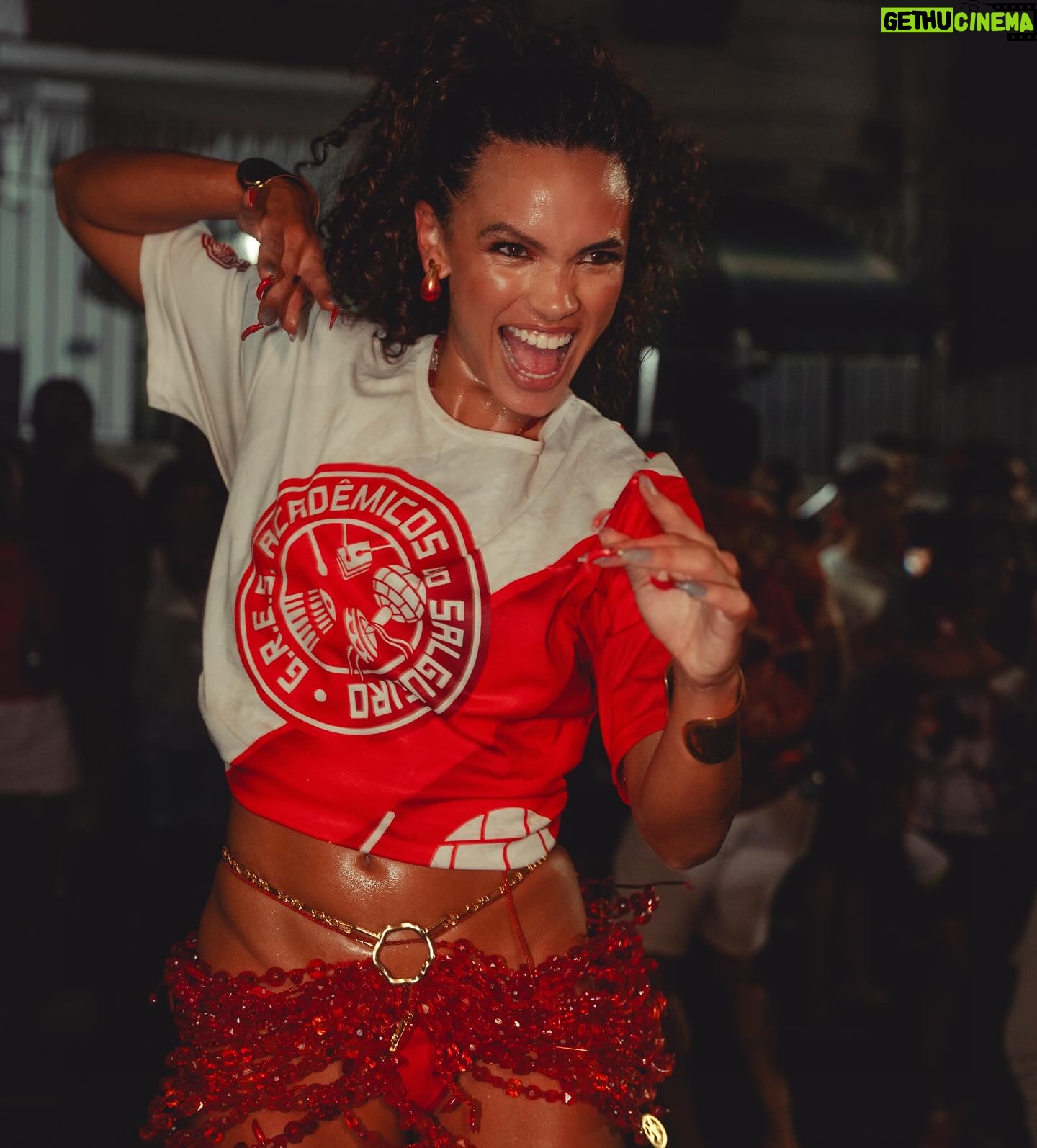 Giovana Cordeiro - 48.5K Likes - A minha fé me faz insistir na arte e a minha arte é sempre o canal para a fé dar um jeito de me deixar saber que eu tô no caminho certo. Elas alimentam uma a outra.
Eu entro em cena quando piso aqui. Pra mim, é tudo a mesma coisa. É tudo expressão, entrega, verdade, estudo e comprometimento. Eu sou artista porque é de arte que eu vivo, é de arte que eu me alimento e tenho profundo respeito por ela. Não quero saber de mais nada.
O Carnaval é também o meu palco. Aqui, assim como em cena, eu percebo de novo a fé apontando um caminho próspero. Reconheço. Agradeço.
Lembro de Dona Marita e de como a minha Umbanda une a minha família e me fez ganhar outra: uma família que me ensina a movimentar junto a natureza. Não tem coisa mais linda que isso.
Percebo que tenho encarado imprevistos de maneira diferente. Não me assusto. Confio. A oportunidade de seguir irradiando enquanto refaço a rota é o que me instiga! Nunca nada veio fácil mesmo. No final das contas parece que sempre foi essa a única opção que a vida me deu: continuar dançando. Arte é insistência. O que me faz artista é meu fôlego.
Pode vir. Não temo. Porque na minha vida tem magia, tem arte, tem festa e tem muito axé. Onde quer que eu vá, que eu celebre a energia de quem nunca me deixa sozinha.
Salve o povo da encruzilhada! LAROYÊ 🌶️