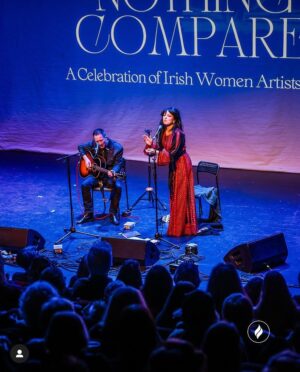 Imelda May Instagram - Last night @theatremoat we celebrated 
with the full spirit of Brigid at ‘Nothing Compares’
Imbas was flowing strongly and so it was a special night. 
Ever supportive  @hotpressmagazine invited us to @theatremoat and our hearts opened as @rachel_skinc @lemoncello___ @unahealy @mariadoylekennedy 
artistry and pure talent blew us all away. 
Nothing prepared me for Ireland’s First Lady 
Sabrina Higgins rousing, truthful and heartfelt speech.
My God she’s a special woman. 
@guitardarling accompanied me with flair and ease. 
The brilliantly slick @thewhitmore hosted with such warmth as always she inspired the audience to be just so open and giving.  Friendship, love, strength, vulnerability, connection all made themselves heard. 
We closed the night with our sister @sineadoconnorofficial words in our hearts and on our tongues, 
Thanks to all including @kildarecountycouncil @jasondohertyphotography @abigailr_photos 
as I wore my Palestinian dress made by @tatreezsisters thinking of all those living in fear and devastation and praying hard for peace and hope..
Because of last night I was in a good place today to feel Brigids quiet power while simultaneously wearing three of my favourite scarves by @loubrennandesign @victoriamaryclarke @jenniferrothwelldesign as 
my Brat Bhride (Brigids Cloak) that I hung on a bushel last night to be blessed by the passing spirit of Brigid and wrap myself in all year when in need of healing. 
Imbolc a blessings upon us all as we spring towards 
new life, new beginnings, love, light and hope.
Love Imelda x