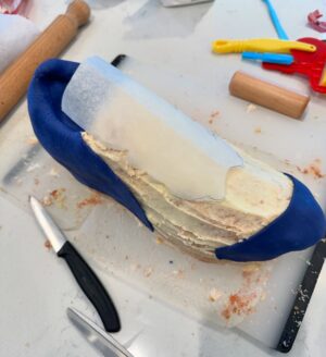 Charlotte Hawkins Instagram - The grand reveal of my trainer cake! As my husband Mark is running the London Marathon for @mndassoc I wanted to do my bit for a fundraising event... and had a bit of a marathon cake-making session inspired by one of his trainers! 👟 I watched a lot of YouTube videos in preparation, having never done this before - but to be honest I’m not sure I’d recommend undertaking it unless you have a spare 12 hours or so 🤣 but here is my method just in case! Not quite ‘Is it Cake’ level but at least it tasted good!! 
I put this on my stories as I was creating it - a big thanks for all the support, it got me through it!! 
• the inspiration
• an awful lot of cake mix
• 4 cakes and the templates - ended up needing 6 cakes!
• Sooo much buttercream….
• Bit of a pit-stop along the way 🤣 
• taking shape but it looks more like a clog at this stage!
• Sticking it all together with jam and buttercream, not the prettiest but it does the job
• Resorting to raiding Ella-Rose’s play-doh box for some modelling tools - a bit of a wash and they worked a treat! 😂
• an awful lot of fondant needed 
• starting the process of sticking it on
• the professionals have what’s called a ‘texture mat’ - I have a cheese grater… 
• templating the tricky sections
• shaping it into the finished article - don’t forget to thread those laces!!
Good luck if you try it 😂 
#cake #isitcake #cakemodelling #cakecraft #mnd #mndassociation #fundraising #londonmarathon