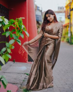 Malavika Sreenath Instagram - Setting drapes and hearts on fire ❤️‍🔥 

Saree from @ekori_official ! Saree’s grace speaks for itself ✨ 

Shot by @muzammilmooza absolutely stunning!💫 

[ saree , saree draping , six yards of elegance, red hair , saree styling , copper gold saree ]