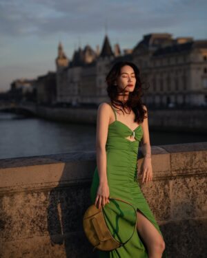 Aviis Zhong Instagram - 那是在Pont-Neuf的黃昏，
週五傍晚，只有10度吧！
人來人往的旅客，並沒有把巴黎最美的橋弄垮，
只是探頭看看我，看看對面的聖母院何時修復好，
想著8年前，我騎著自行車經過這座橋，
唯一沒變的是，
風一樣大。

It was dusk at Pont-Neuf,
a Friday evening, probably around 10°C.
Tourists came and went, but they didn’t crush the most beautiful bridge in Paris.
They just glanced at me,
then at Notre-Dame across the river, wondering when it would be fully restored.
I thought about eight years ago,
when I rode my bike across this bridge.
The only thing that hasn’t changed，
The wind，
it’s just as strong.

@longchamp 

#LongchampLiveGreen
#最愛這組照片了

photographer： @h_paris_h 
Make- up： @backstage_aga 
Hair： @hc_kila 
Manage team： @lemon0825  @kuoshuyu729