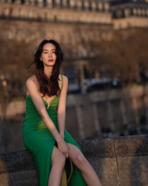 Aviis Zhong Instagram - 那是在Pont-Neuf的黃昏，
週五傍晚，只有10度吧！
人來人往的旅客，並沒有把巴黎最美的橋弄垮，
只是探頭看看我，看看對面的聖母院何時修復好，
想著8年前，我騎著自行車經過這座橋，
唯一沒變的是，
風一樣大。

It was dusk at Pont-Neuf,
a Friday evening, probably around 10°C.
Tourists came and went, but they didn’t crush the most beautiful bridge in Paris.
They just glanced at me,
then at Notre-Dame across the river, wondering when it would be fully restored.
I thought about eight years ago,
when I rode my bike across this bridge.
The only thing that hasn’t changed，
The wind，
it’s just as strong.

@longchamp 

#LongchampLiveGreen
#最愛這組照片了

photographer： @h_paris_h 
Make- up： @backstage_aga 
Hair： @hc_kila 
Manage team： @lemon0825  @kuoshuyu729
