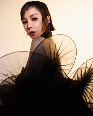 Fiona Xie Instagram - The Alchemy of @irisvanherpen @voguesingapore 

“I find beauty in the continual shaping of chaos which embodies the primordial power of nature’s performance,” Iris van Herpen once said—words that illuminated my understanding of her work at the nexus of ancient alchemy and @cern physics.

Her liminality is her genius. “I see technology as a tool to express the handwork better,” she explains, dissolving false binaries. When her kinetic structures breathe with the wearer, we witness her core philosophy: “Movement is my constant inspiration. Our human body is in continuous motion, as is everything around us.”

These undulating architectures manifest what philosopher Merleau-Ponty called “the flesh of the world”—the profound interconnectedness between perceiver and perceived. Her approach transforms rigid materials into liquid motion, embodying Bachelard’s insight that “matter is the unconsciousness of form.”

I remember showing my friend @grimes in that “Dune of Souls” creation at the met gala whispering “It would be a dream to wear these.” Then @voguesingapore @nat_tasha ‘s call came—Iris would dress me for the @artsciencemuseumsg retrospective. I swooned like a teenager locked lips in her first kiss. Manifestation is real. 

“Fashion is an expression of the zeitgeist, while couture is an expression of eternal beauty.” These words resonated as I stood transfixed clad in her “Architectonics” collection—embodying what Rilke meant by “living the questions” about our relationship with technology, philosophy, architecture, music, nature, and our bodies.

Draped in her vision, I understood: Iris van Herpen doesn’t design clothing. She designs portals to possibility itself.​​​​​​​​​​​​​​​​

Be transcended at @artsciencemuseumsg 
#IrisVanHerpen #ArtAndFashion #Metamorphosis​​​​​​​​​​​​​​​​ #Vogue