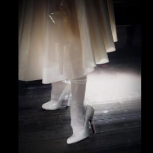 Gwendoline Christie Instagram - Maison Margiela Artisanal 2024 Collection by @jgalliano .

Look 44
Overdress and an underdress in white silk taffeta with retrograding in seeping silicone coating worn over a blue-and-white striped cotton poplin stripe-tease corset and a white silk knitted bodysuit, underpinned by a silicone hip prothèse matching the skin tone of the  muse. A porcelain-imitation moulded leather breastplate, a white leather small top-handle Snatched bag, white silk stockings, and white leather pumps by Christian Louboutin for Maison Margiela enveloped in white stocking material. White paper maché, clay, string and stretch-tulle lay doll gloves overlaid in white silk jersey.
Model @gwendolineuniverse

@maisonmargiela 🤍